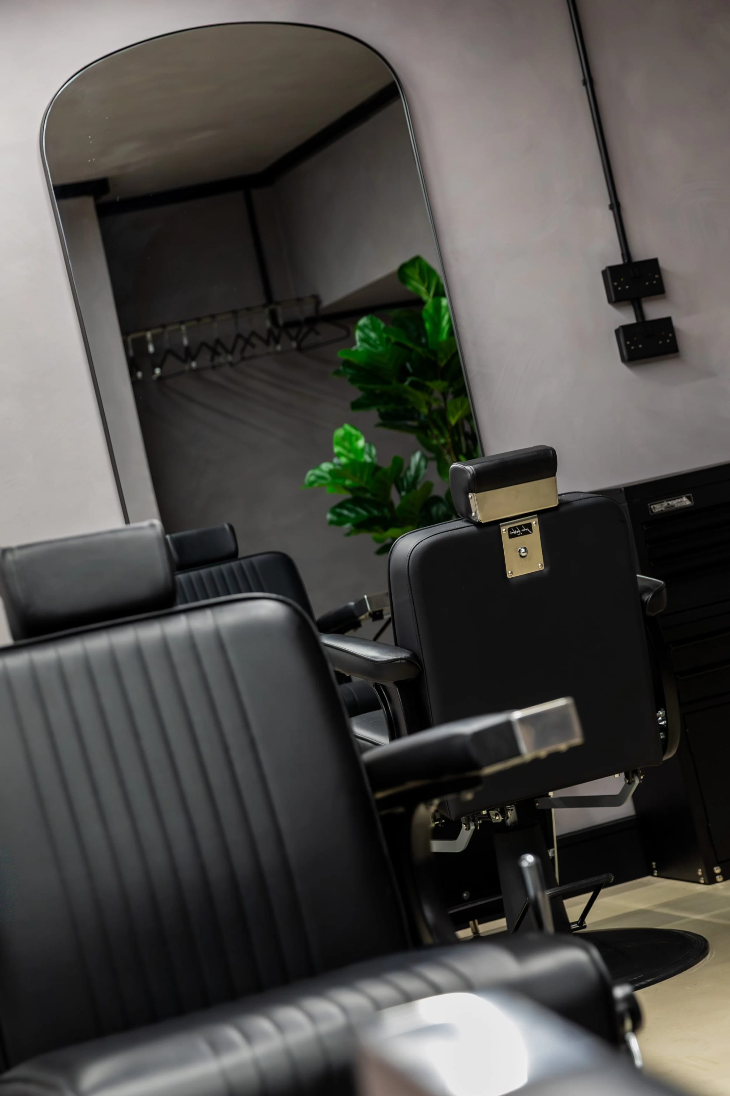 Black leather barber chairs and arched mirrors at The P2 Collective